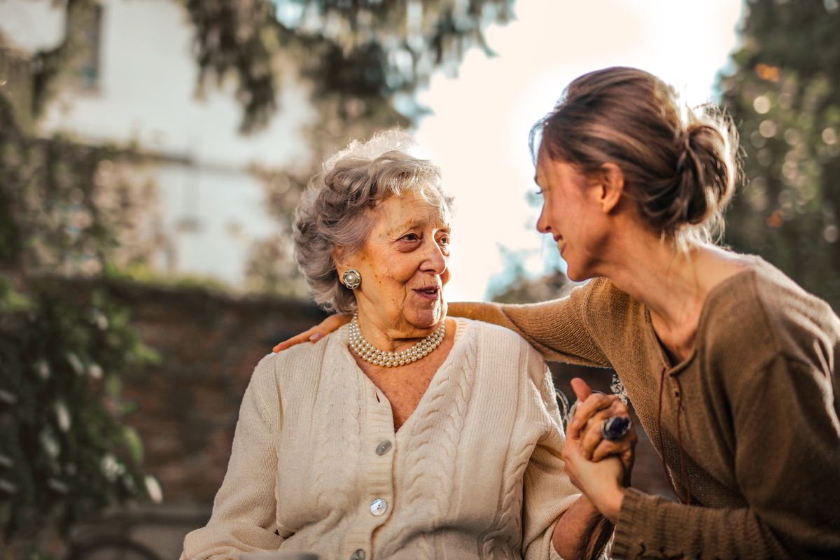 Caregiver sharing a joyful moment with a senior woman at home